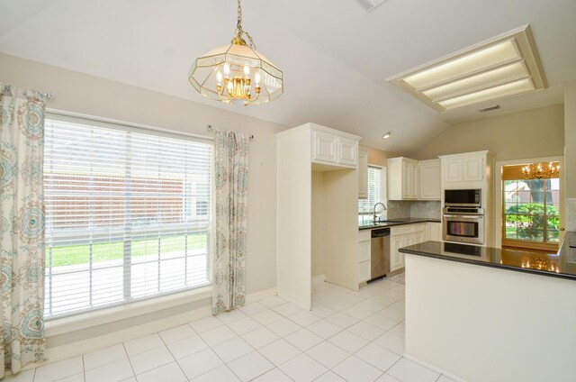 2303 Reflection Ct, Missouri City, TX 77459 - kitchen with appliances with stainless steel finishes, a chandelier, dark countertops, a sink, and vaulted ceiling