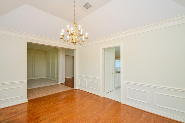 2303 Reflection Ct, Missouri City, TX 77459 - spare room featuring light wood finished floors, a decorative wall, a chandelier, vaulted ceiling, and a wainscoted wall