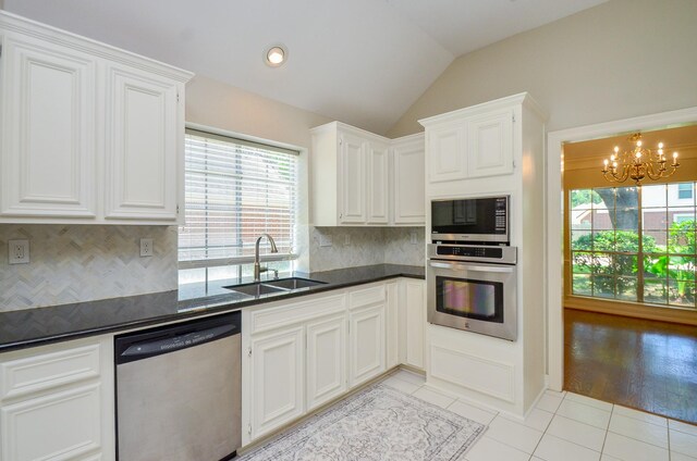 2303 Reflection Ct, Missouri City, TX 77459 - kitchen featuring stainless steel appliances, a sink, light tile patterned flooring, a chandelier, and lofted ceiling