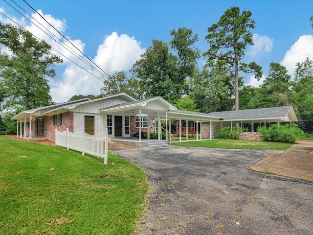 200 Platt Rd, Lufkin, TX 75901 - single story home featuring driveway, covered porch, brick siding, a front yard, and board and batten siding