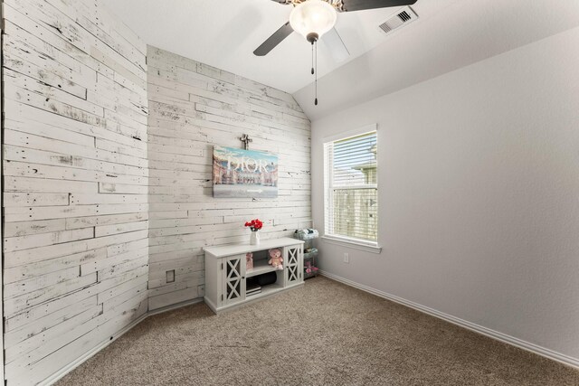 game room with ceiling fan, light colored carpet, wooden walls, lofted ceiling, and baseboards