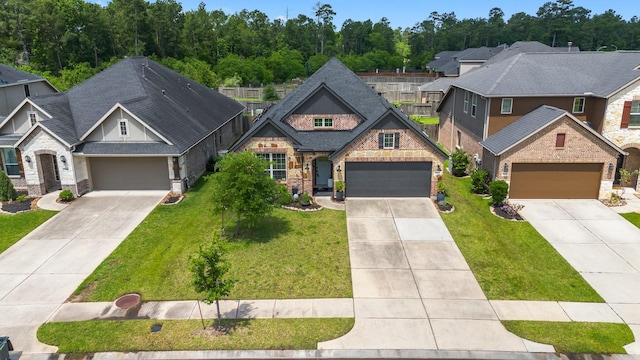 view of front of home with driveway, stone siding, a front yard, and a residential view