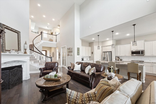 809 Stella Vista Ct, Katy, TX 77493 - living area with dark wood-style floors, stairway, a towering ceiling, recessed lighting, and a fireplace
