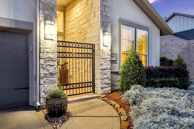 13234 James Terrace Ln, Houston, TX 77059 - view of exterior entry featuring stone siding, a gate, and stucco siding
