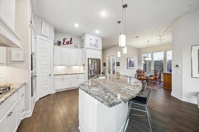 13234 James Terrace Ln, Houston, TX 77059 - kitchen featuring appliances with stainless steel finishes, range hood, dark wood-style floors, recessed lighting, and a sink