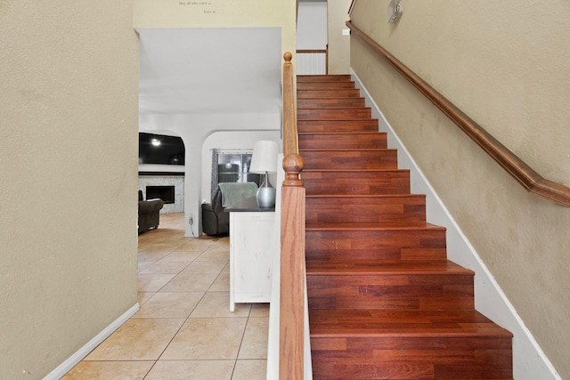 405 Spencer Lndg W, La Porte, TX 77571 - stairway with tile patterned floors, a fireplace, and a textured wall