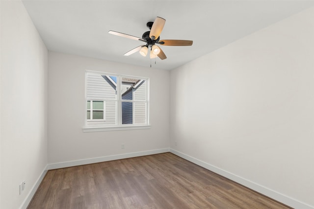 unfurnished room featuring wood finished floors, baseboards, and ceiling fan