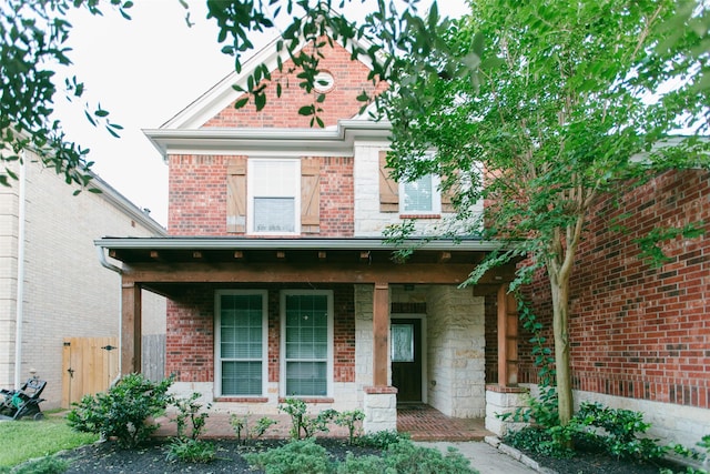 view of front of home with a porch and fence