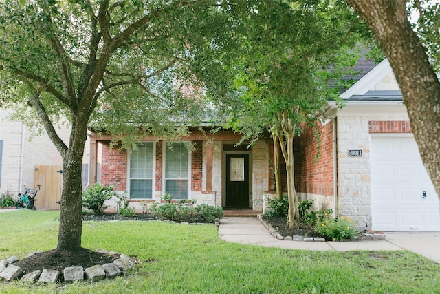 obstructed view of property featuring an attached garage, a front yard, and brick siding