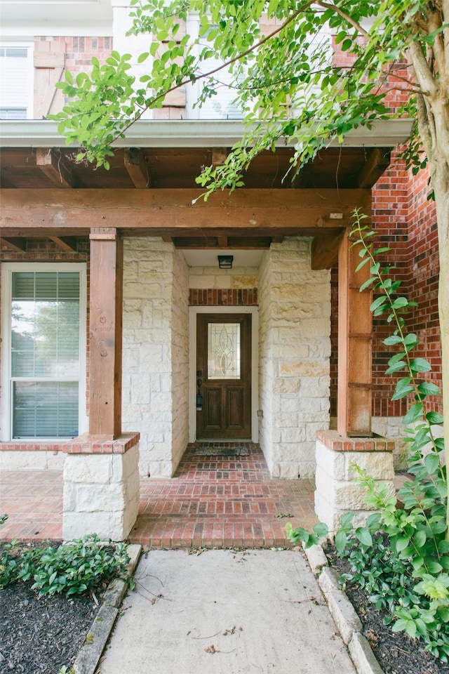 property entrance featuring stone siding and a porch