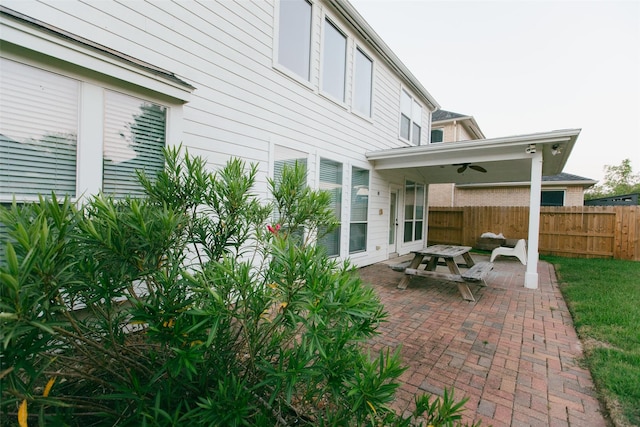 rear view of house featuring fence, a ceiling fan, and a patio