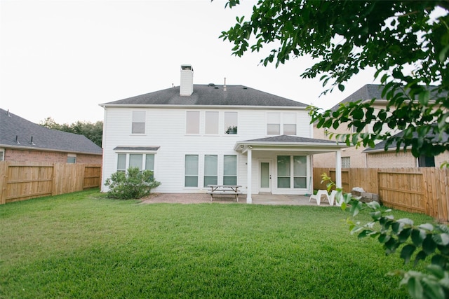 back of property with a chimney and a patio area