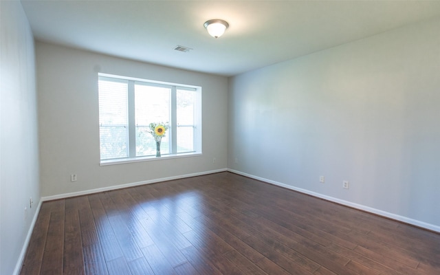 unfurnished room with dark wood-type flooring and baseboards
