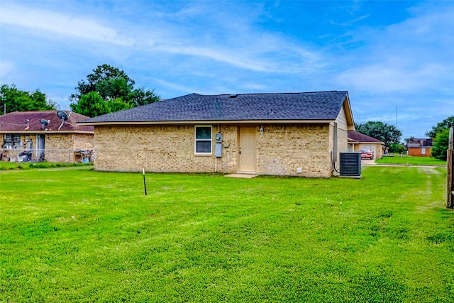 742 Pine Ave, Hempstead, TX 77445 - back of house with cooling unit, a yard, brick siding, and roof with shingles