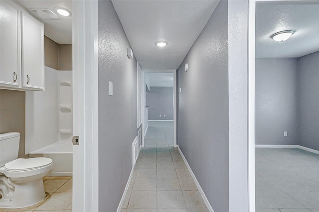742 Pine Ave, Hempstead, TX 77445 - hallway featuring light tile patterned flooring, baseboards, and a textured wall
