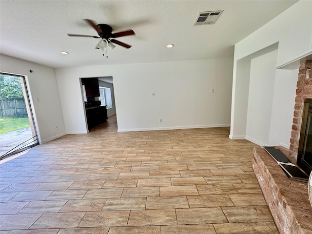 unfurnished living room with ceiling fan, baseboards, a fireplace, recessed lighting, and light wood-style floors
