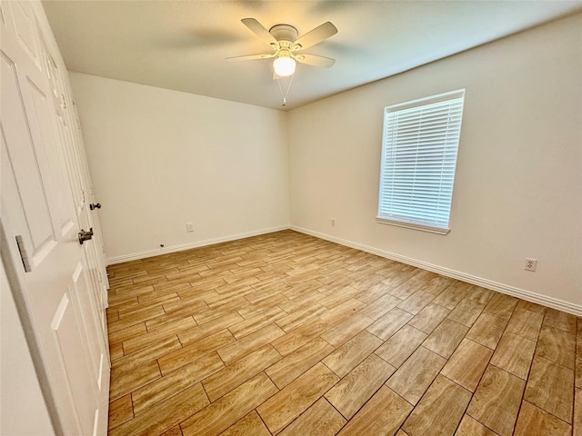 empty room with light wood-type flooring, ceiling fan, and baseboards