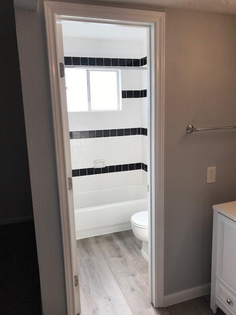 13702 Towne Way Dr, Sugar Land, TX 77498 - bathroom featuring wood finished floors, toilet, shower / washtub combination, and vanity