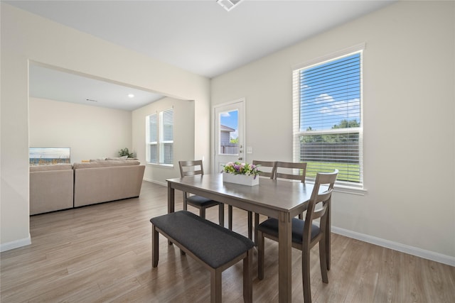 dining area featuring healthy amount of natural light, light wood finished floors, and baseboards