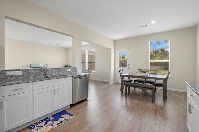 kitchen with stainless steel dishwasher, a sink, light wood-type flooring, stone counters, and recessed lighting