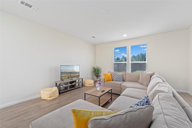 living room featuring wood finished floors, baseboards, and recessed lighting