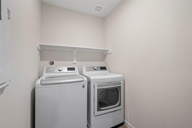 laundry area with separate washer and dryer and baseboards