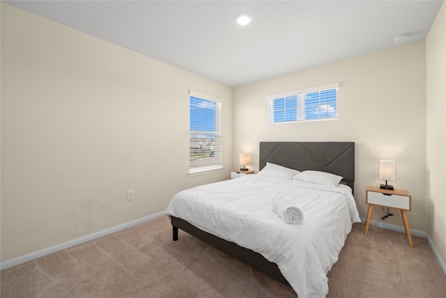 bedroom featuring light carpet and baseboards