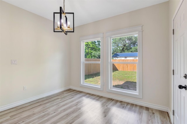1107 N Main St, Dayton, TX 77535 - unfurnished dining area featuring light wood finished floors, a chandelier, and baseboards