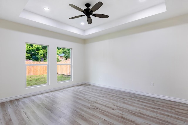 1107 N Main St, Dayton, TX 77535 - spare room with a tray ceiling, light wood-type flooring, recessed lighting, and baseboards