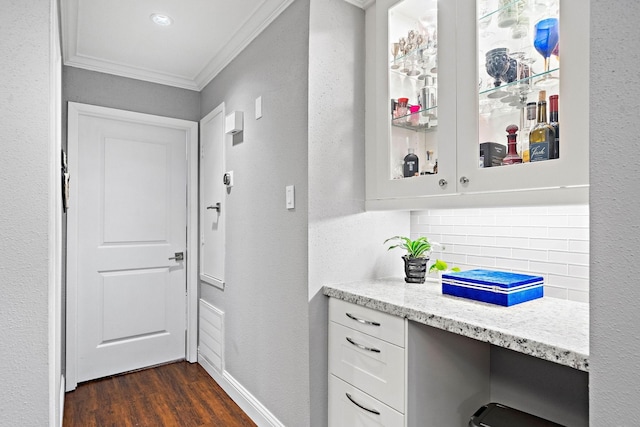 hall with ornamental molding, dark wood-style floors, an office area, baseboards, and a textured wall