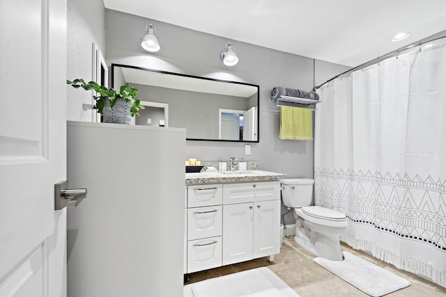 bathroom featuring toilet, vanity, and a shower with curtain