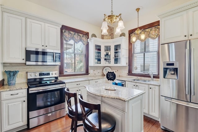 kitchen featuring appliances with stainless steel finishes, a chandelier, healthy amount of natural light, and a sink