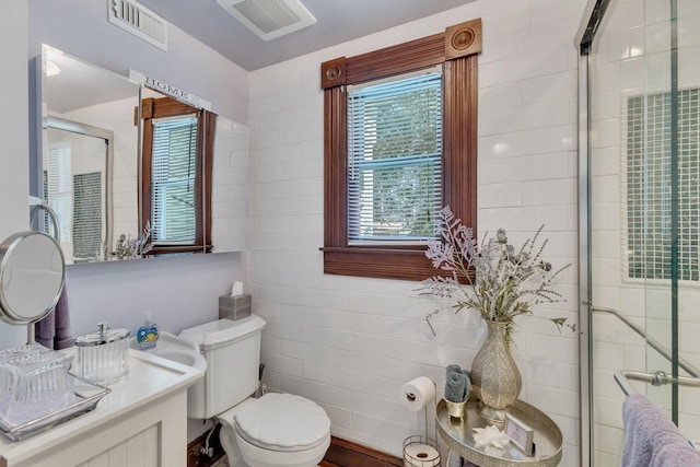 full bathroom featuring a stall shower, toilet, and tile walls