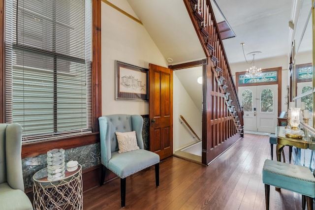 foyer entrance featuring a chandelier, hardwood / wood-style flooring, stairway, and lofted ceiling