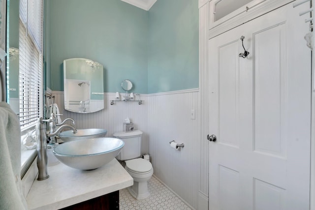 bathroom featuring a wainscoted wall, toilet, vanity, and tile patterned floors