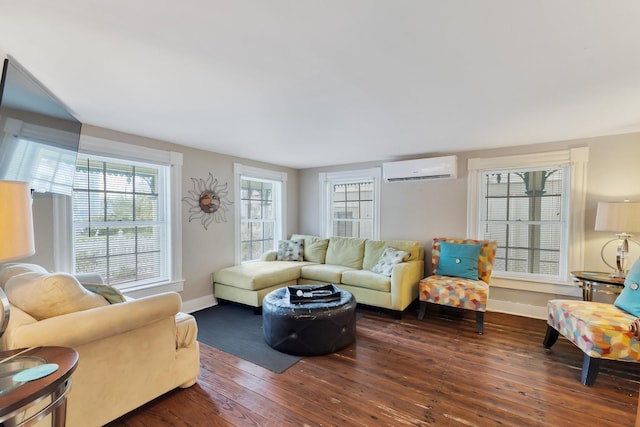 living area with wood-type flooring, baseboards, and a wall mounted air conditioner