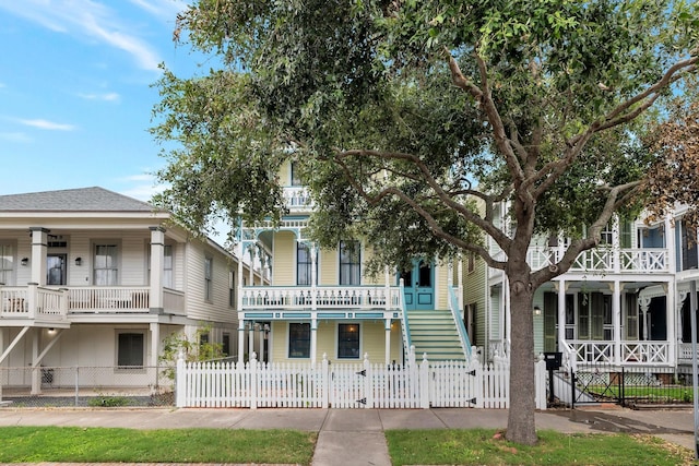 view of front of home featuring a gate, a fenced front yard, stairway, and a porch