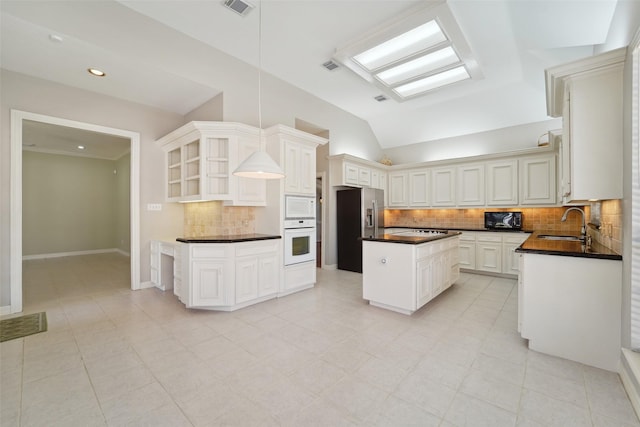1706 Lofty Maple Trl, Houston, TX 77345 - kitchen with white appliances, dark countertops, a sink, open shelves, and a center island