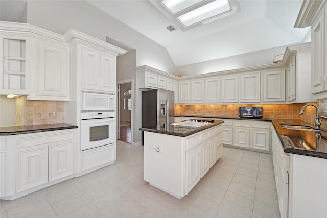 1706 Lofty Maple Trl, Houston, TX 77345 - kitchen featuring white appliances, a sink, decorative backsplash, vaulted ceiling, and dark stone counters