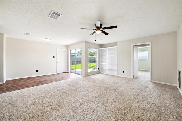 carpeted spare room featuring ceiling fan, a textured ceiling, healthy amount of natural light, and baseboards