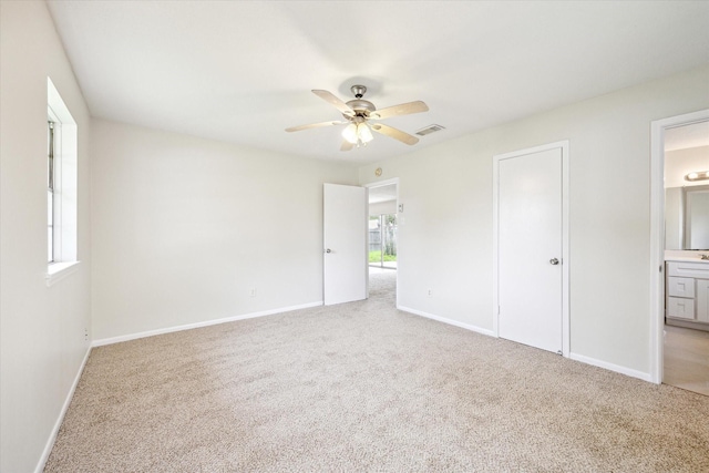 unfurnished bedroom with light colored carpet, multiple windows, and baseboards