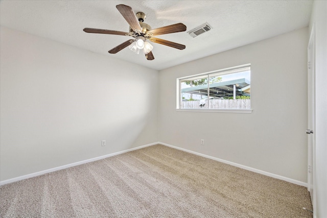 carpeted empty room with baseboards, ceiling fan, and a textured ceiling