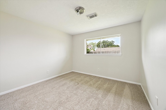 unfurnished room with carpet floors, baseboards, and a textured ceiling