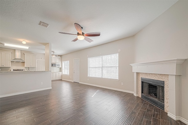 23123 Sandpiper Trl, Spring, TX 77373 - unfurnished living room with a ceiling fan, dark wood-style floors, a fireplace, baseboards, and a textured ceiling