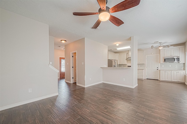 23123 Sandpiper Trl, Spring, TX 77373 - unfurnished living room featuring dark wood-style flooring, ceiling fan, baseboards, and a textured ceiling