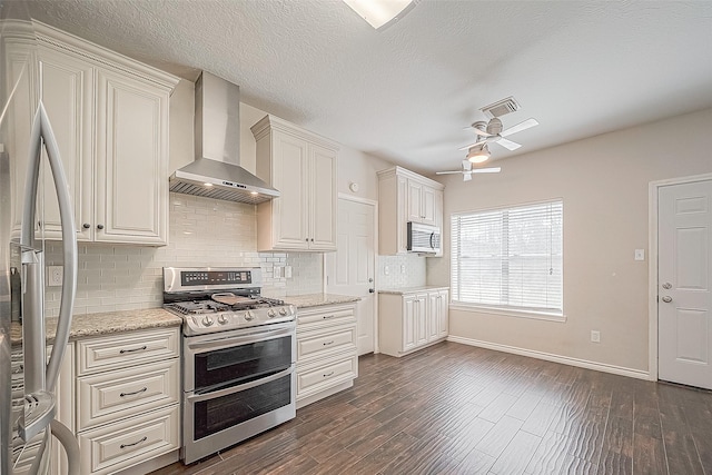 23123 Sandpiper Trl, Spring, TX 77373 - kitchen featuring appliances with stainless steel finishes, wall chimney range hood, a ceiling fan, baseboards, and tasteful backsplash