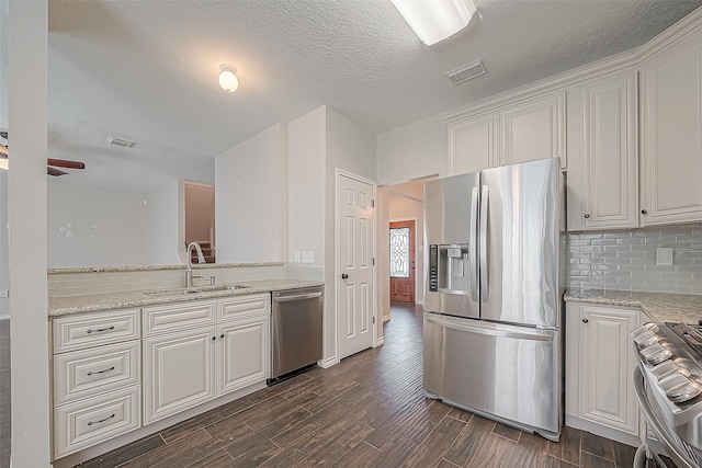 23123 Sandpiper Trl, Spring, TX 77373 - kitchen with stainless steel appliances, a sink, dark wood-style flooring, backsplash, and a textured ceiling