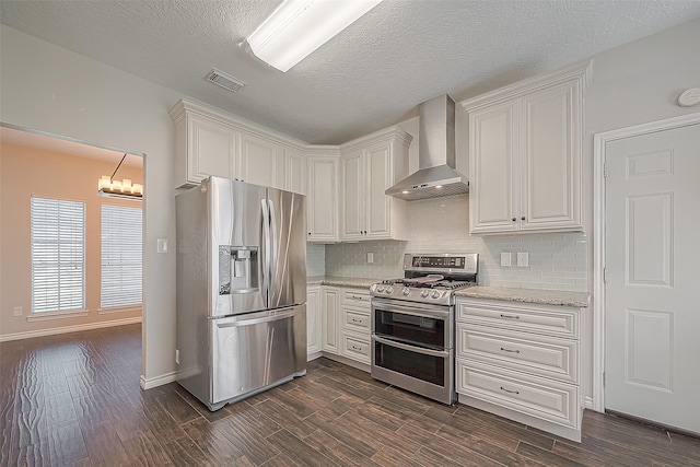 23123 Sandpiper Trl, Spring, TX 77373 - kitchen with stainless steel appliances, wall chimney exhaust hood, backsplash, dark wood-style flooring, and a textured ceiling
