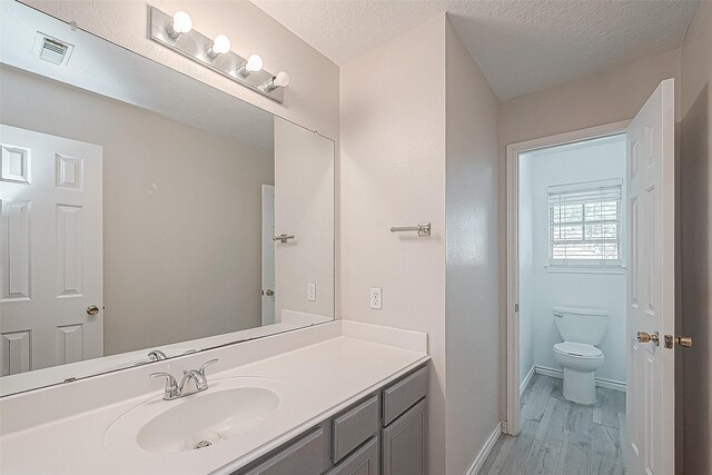 23123 Sandpiper Trl, Spring, TX 77373 - bathroom with wood finished floors, toilet, vanity, and baseboards