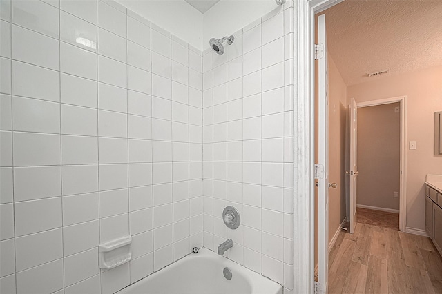 23123 Sandpiper Trl, Spring, TX 77373 - full bathroom with wood finished floors, bathing tub / shower combination, vanity, a textured ceiling, and baseboards